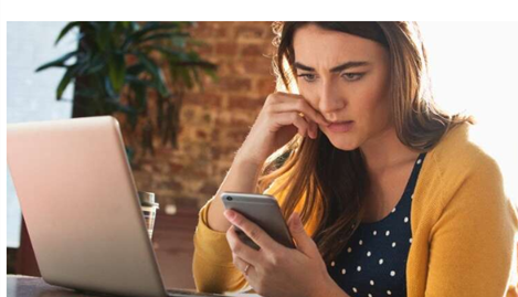 worried woman with phone and laptop